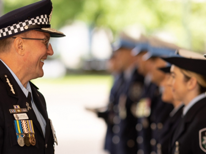 A line of police officers being greeted by a senior officer
