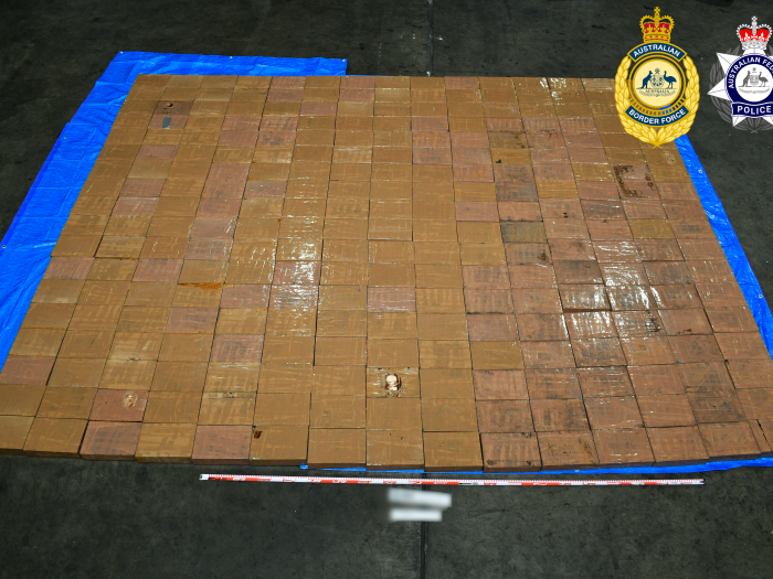 Multiple brown looking blocks of methamphetamine laid out on a blue tarp