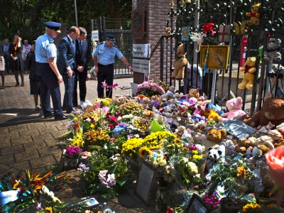 Police officers and then Prime Minister Tony Abbott observing a memorial of flowers in the Ukraine
